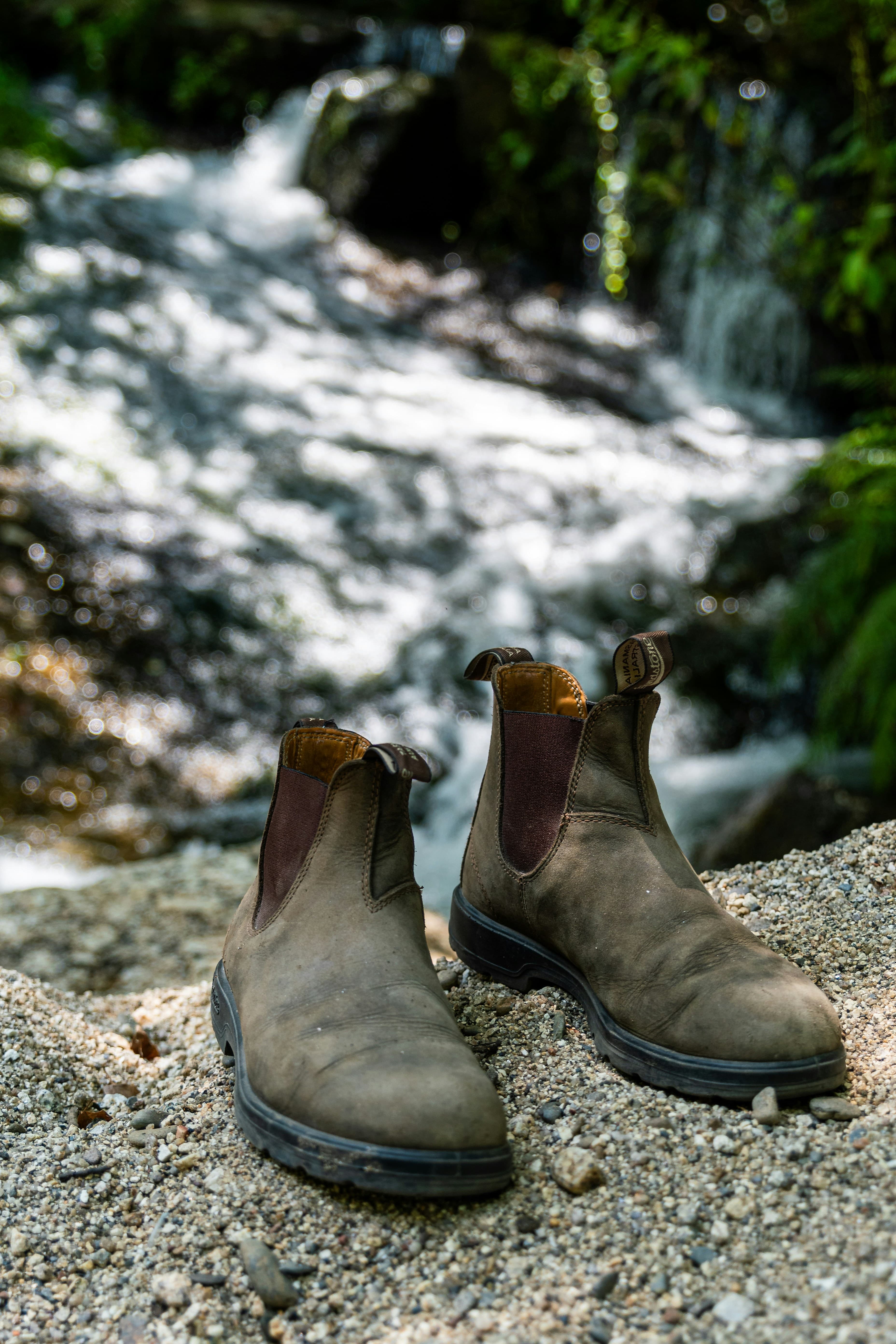 A pir of Blundstone boots next to a river
